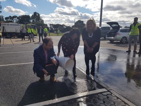 Mahdi Disfani, Lina Goodman and Mayor Heather Holmes-Ross pouring water over the permeable paving.