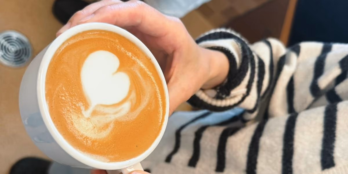 A cup of coffee with a heart pattern