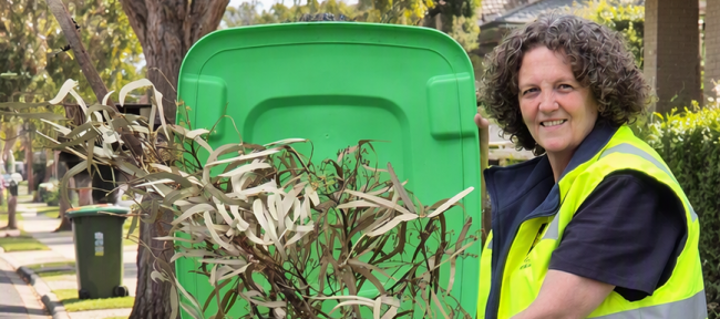 Kerry from Council placing an branch into a green bin