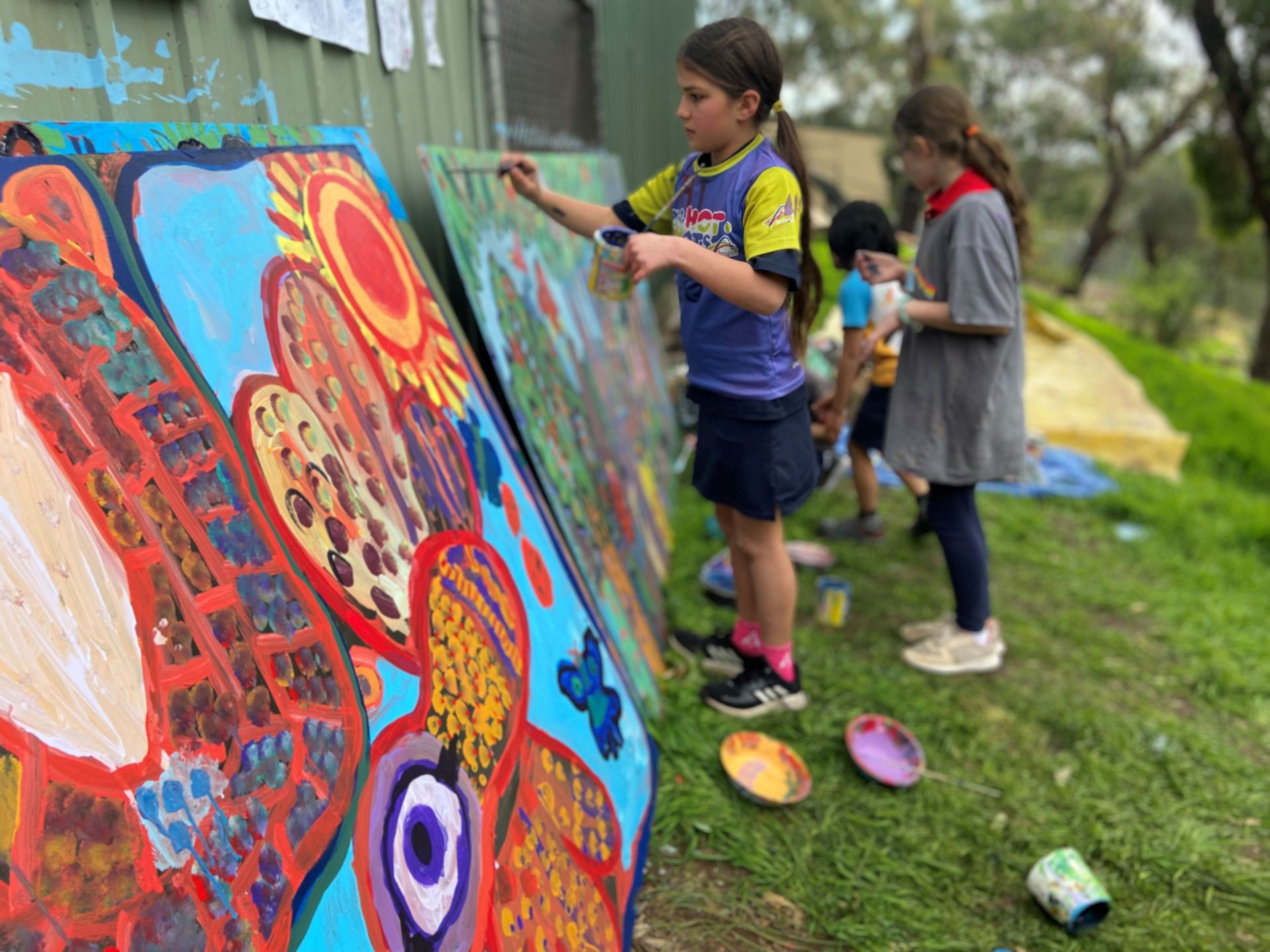 Students from Eden Hills Primary School painting the Grey Box Grassy Woodland Mural