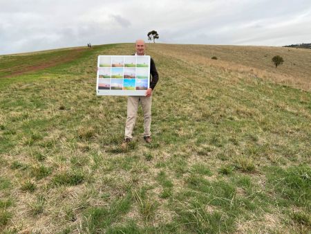 Artist David Hume with his photography art Installation that captured the lone tree atop Brown Hill across seasons.