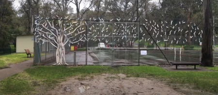 Artist Aiyudot Khom created a tree in winter to celebrate spring in Four Seasons of Play on the fence at Apex Park