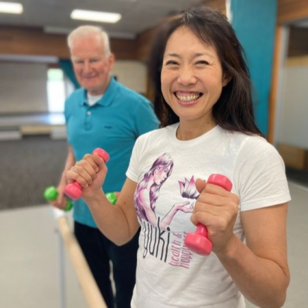 A group of people participating in an exercise class using equipment