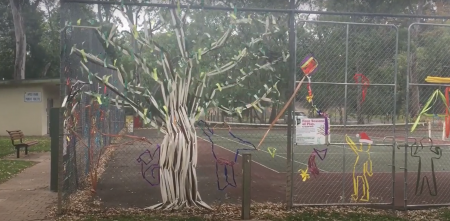 Artist Aiyudot Khom created a summer tree to celebrate spring in Four Seasons of Play on the fence at Apex Park