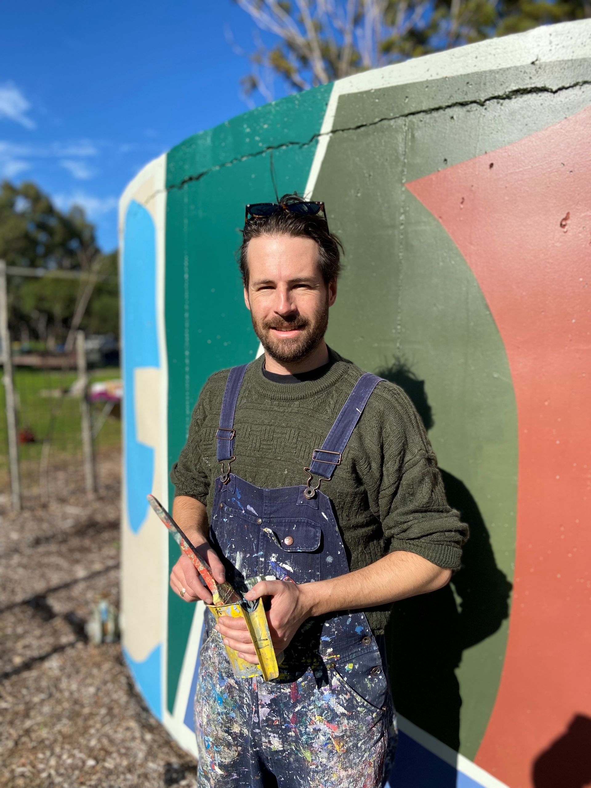 Artist Tristan Kerr standing in front of his mural Together 2022 at Donald Street Reserve in St Marys